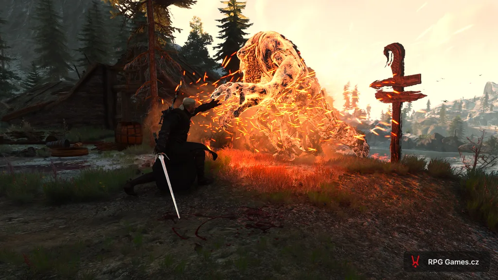 Geralt vrhá Igni na ledového obra u trosek vesnice — oranžové plameny na modré kůži, Zaklínač 3
