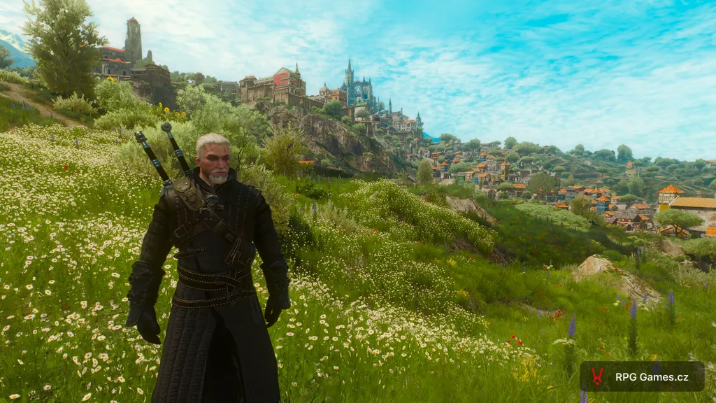 Geralt na louce v Toussaintu ve hře Zaklínač 3 — Beauclair a vinařské kopce v pozadí